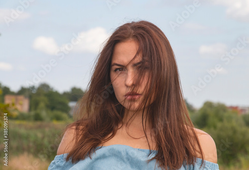Portrait of a beautiful brunette outdoors, hair in the wind