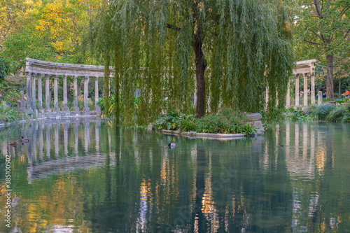 Paris, France - 10 11 2020: Golden hour in Parc Monceau in autumn. Oval basin bordered by a Corinthian colonnade photo