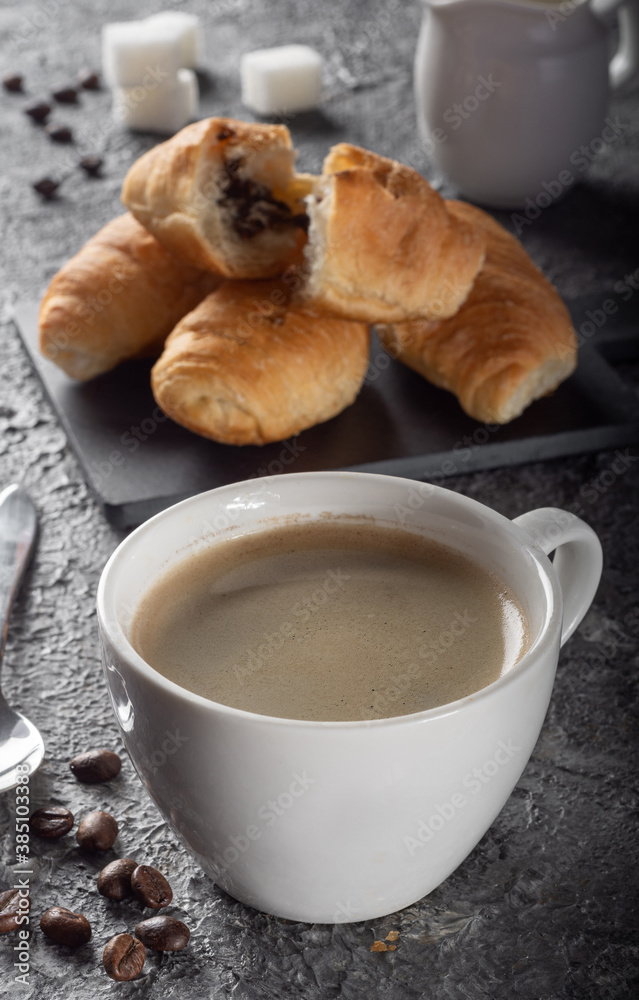 Fresh brewed Americano coffee with foam with mini croissants. Coffee with chocolate croissants Fresh brewed Americano coffee with foam with mini croissants. Coffee with chocolate croissants