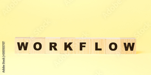 word workflow with small wooden blocks on yellow background