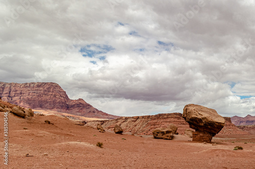 Precariously balancing rock on a dry barren landscape, Vermillion cliff range, Page, AZ, USA