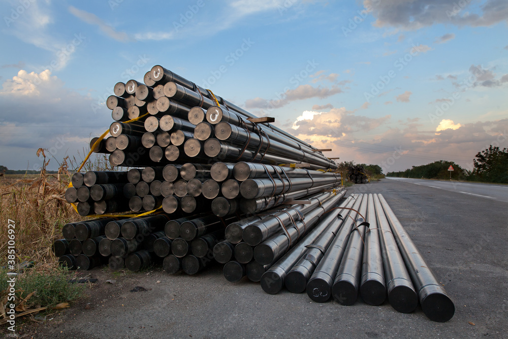 Obraz premium Heap of insulated pipes for natural gas at construction site side a road