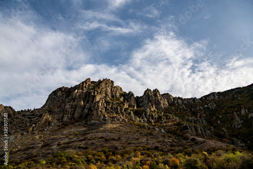 panoramic view of yellow autumn mountains against a background of blue haze and storm clouds
