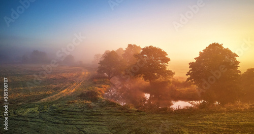 Obraz na płótnie Autumn foggy river sunrise. Colorful misty morning dawn. Fall rural scene panorama w salonie