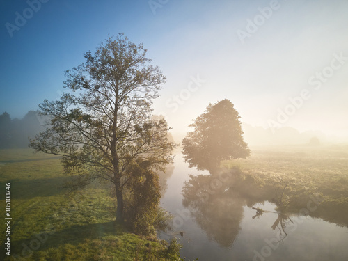 Obraz na płótnie Autumn foggy sunrise. Fall rural scene. Small river with trees w salonie