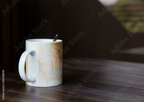 White cup on table and dark background