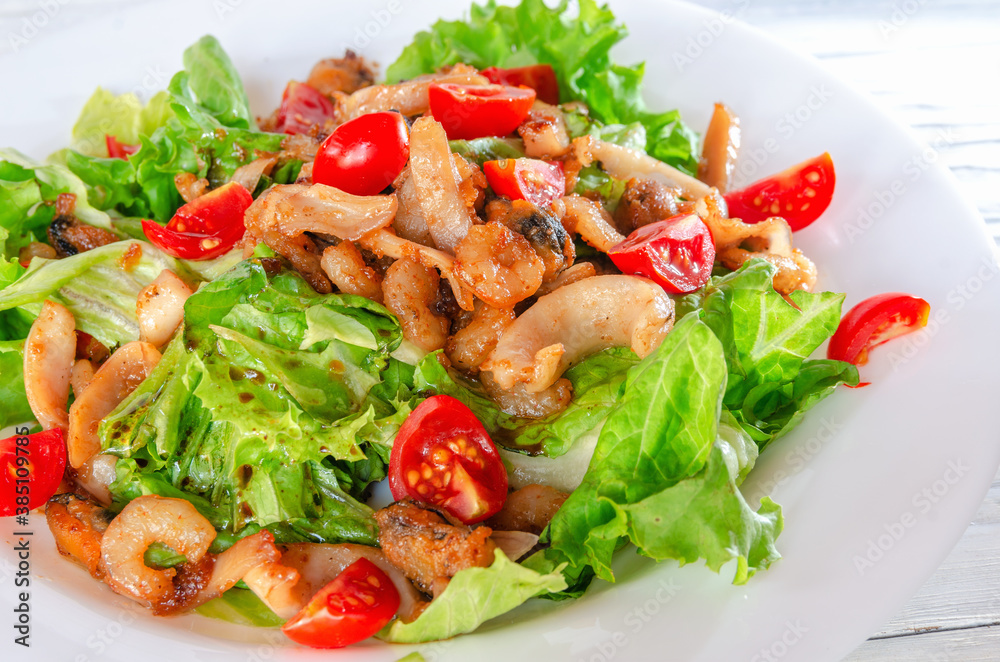 summer vegetable salad on a white dish on a wooden background