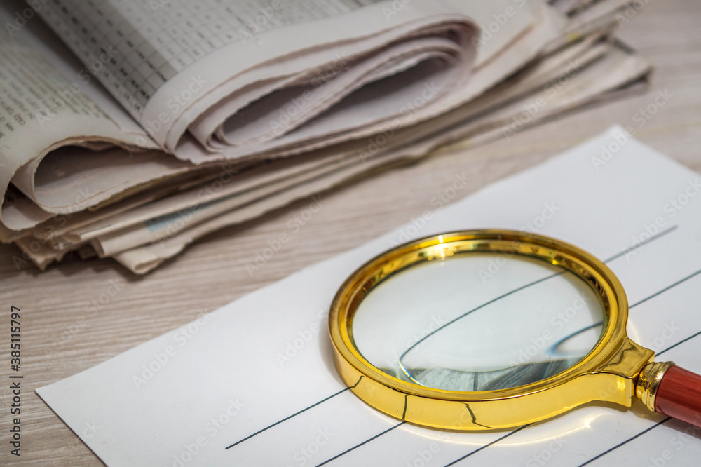 Magnifying glass for reading newspapers on letterhead. Home environment