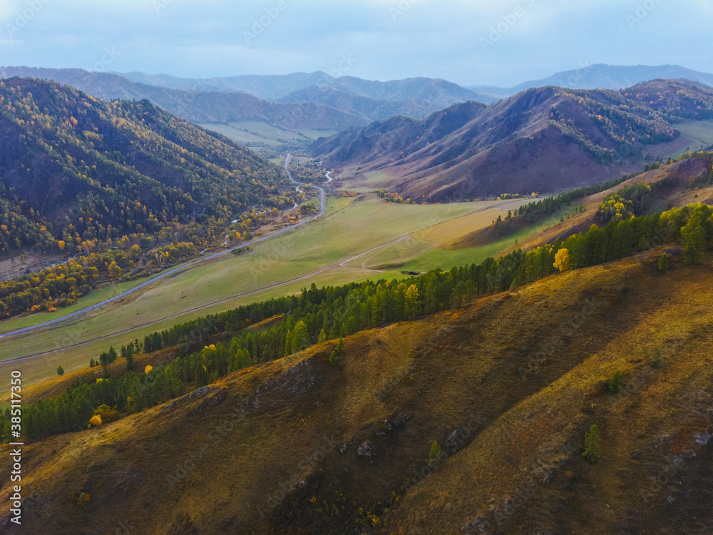 Aerial panoramic view of autumn mountain landscape at sunset. Drone shooting of scenic autumn backgrounds Aerial panoramic view of autumn mountain landscape at sunset. Drone shooting of scenic autumn backgrounds