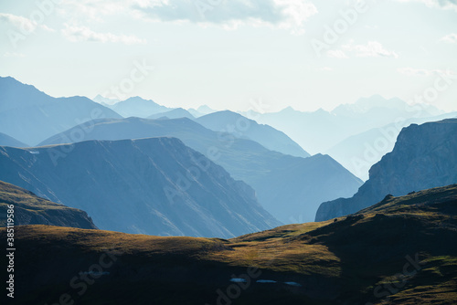 Awesome aerial view to great mountains in distance behind deep gorge. Scenic mountain landscape with giant rockies and deep abyss. Wonderful highland scenery with huge cliff. Big rocks and precipice.