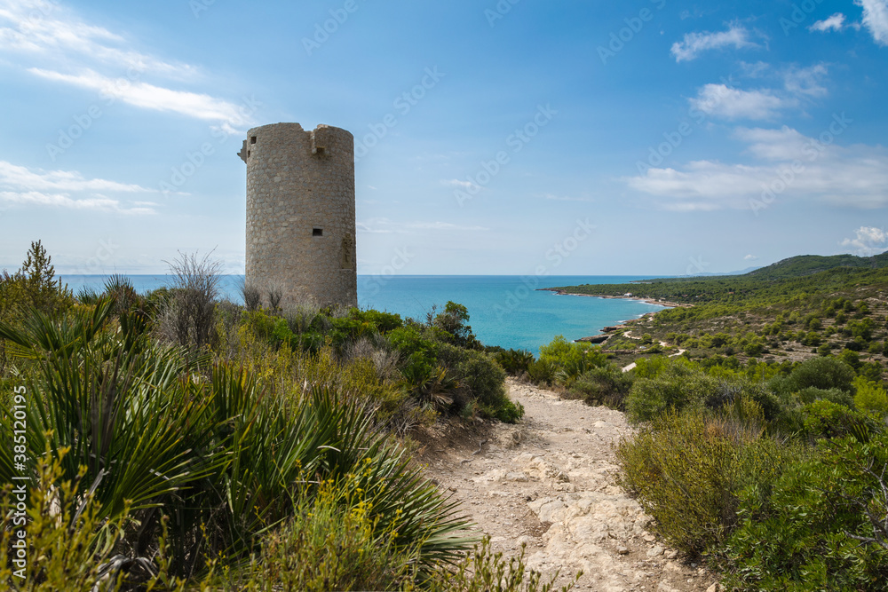 Natural landscape of Sierra de Irta Park with Badum sentinel tower on a summer day with blue sky, Peniscola, Castellon, Spain