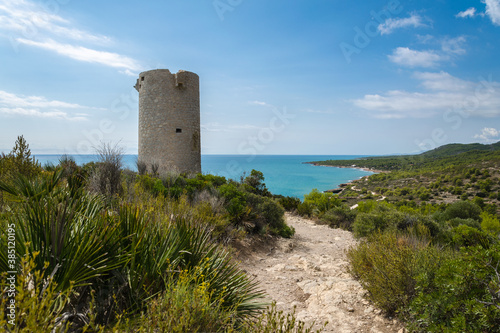 Natural landscape of Sierra de Irta Park with Badum sentinel tower on a summer day with blue sky, Peniscola, Castellon, Spain