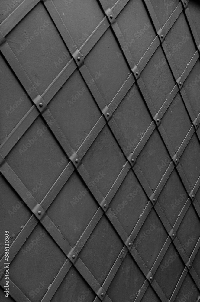 Metal fence with forged stripes laid out in the form of rhombuses