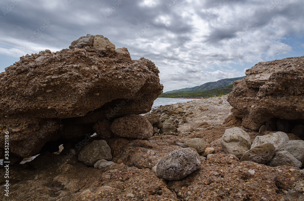 Lonely Mediterranean rocky beach in Sierra de Irta Natural Park under a cloudy and stormy sky, Castellon, Spain