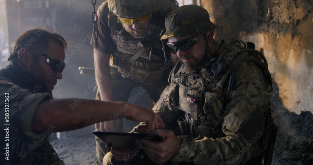 Male soldiers using smartphone together Male soldiers using smartphone together