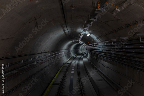 Construction site of the subway tunnel with blurred light tracks. Underground facility leading deep down.