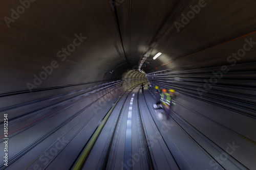Construction site of the subway tunnel with blurred light tracks. Underground facility leading deep down.