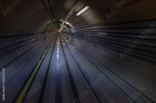 Construction site of the subway tunnel with blurred light tracks. Underground facility leading deep down.