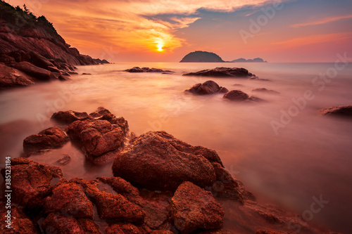 Long exposure photo of a warm sunset on the rocky beach of Redang Island, Malaysia photo