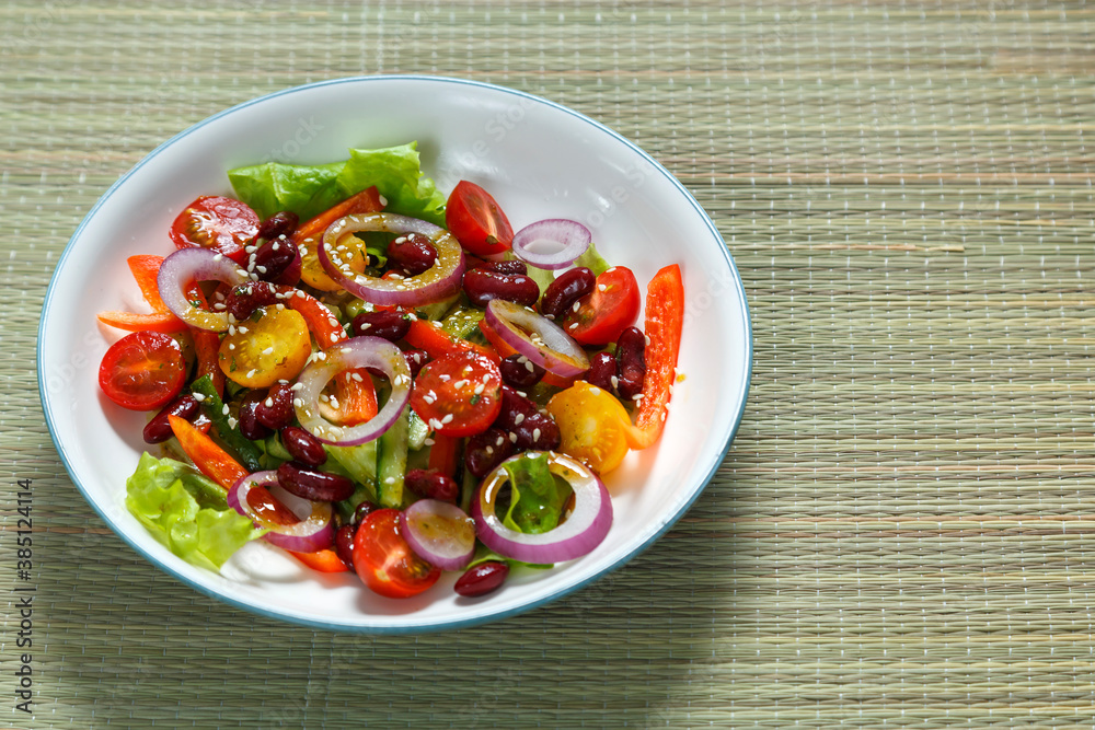Light plate with pan-Asian salad with sesame seeds and tamarind on a bamboo tablecloth