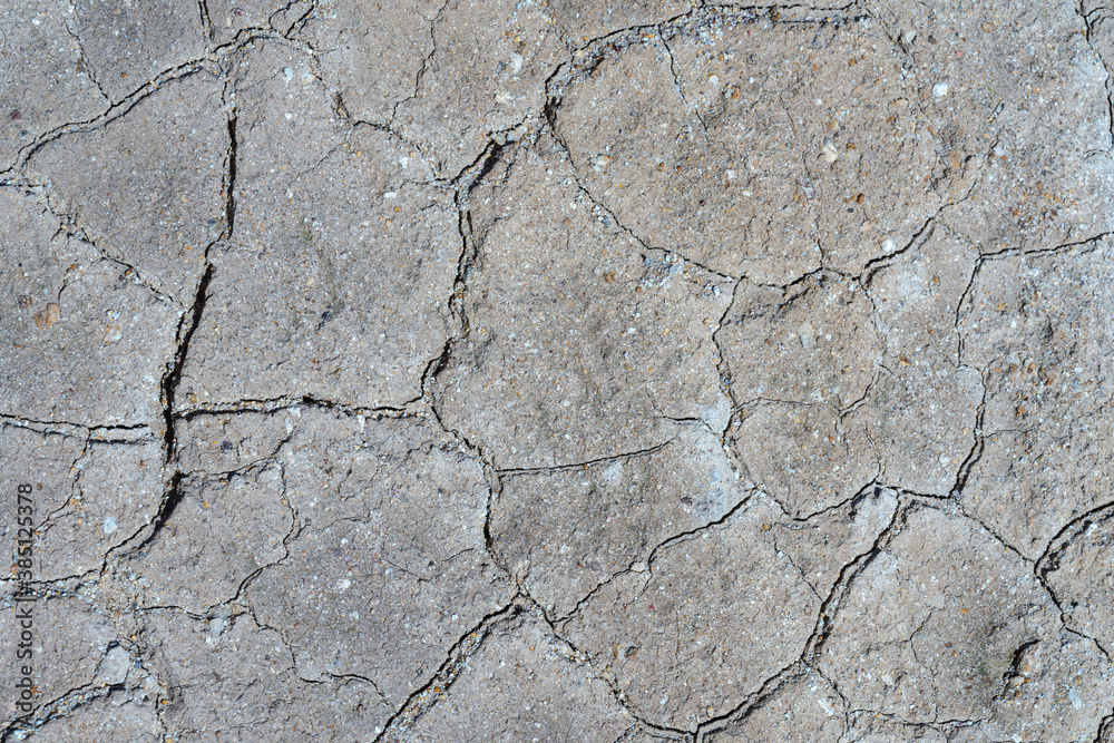 Gray dry cracked surface of volcanic ground turned into desert. Natural pattern texture or background taken in environment in crater of active volcano. Concept: drought soil erosion, global warming. Gray dry cracked surface of volcanic ground turned into desert. Natural pattern texture or background taken in environment in crater of active volcano. Concept: drought soil erosion, global warming.