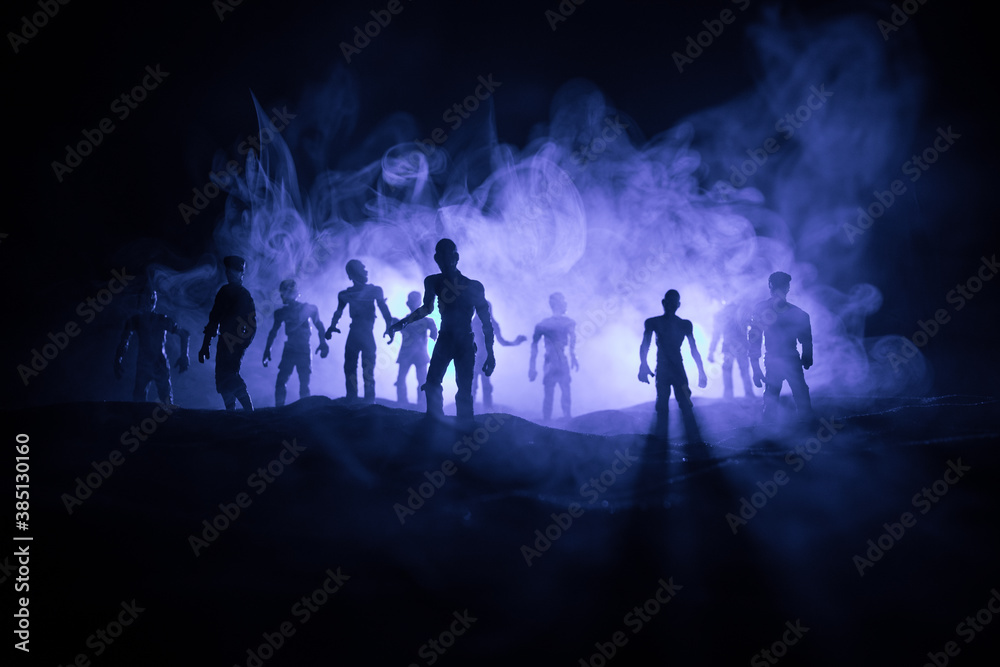 Scary view of zombies at cemetery dead tree, moon, church and spooky cloudy sky with fog, Horror Halloween concept with glowing pumpkin. Selective focus Scary view of zombies at cemetery dead tree, moon, church and spooky cloudy sky with fog, Horror Halloween concept with glowing pumpkin. Selective focus