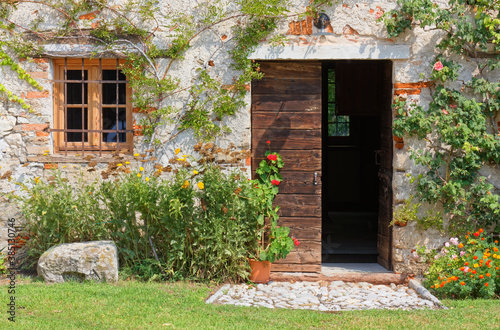 Exterior of an old traditional rural building deorated with plants and flowers photo