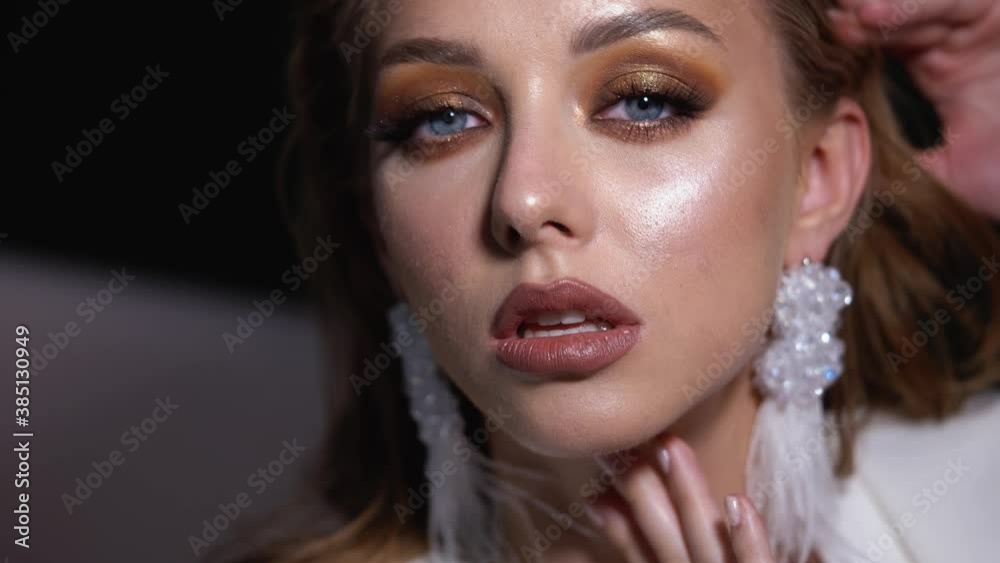 Blonde model with bright evening makeup. Beauty, fashion. Girl posing in studio with beautiful makeup 4K