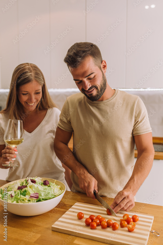 young couple laughing and working together with copy space in a nice kitchen young couple laughing and working together with copy space in a nice kitchen