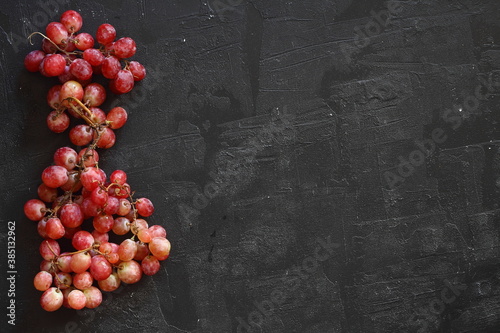 Bunch of fresh ripe juicy red grape flat lay on white background, copy space for text photo