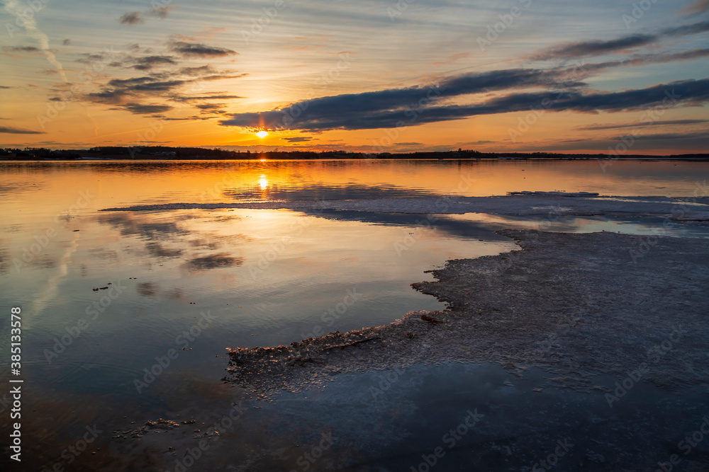 Winter landscape with frozen ice sheets floating on a lake during a late sunset in Charlottetown, Prince Edward Island, Canada.