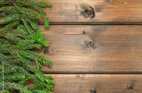 Green fir branches on a wooden background. Natural spruce branch on a wooden table made of boards. Layout for new year and christmas. preparation for congratulations.