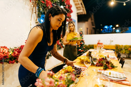 Christmas dinner in Brazil. Women prepare a table in the garden for Christmas dinner. photo