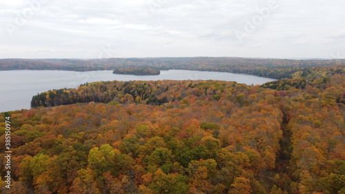 Scenic Aerial View of Fall Autumn Colours in the Countryside with Vibrant Orange Coloured Trees and a Lake