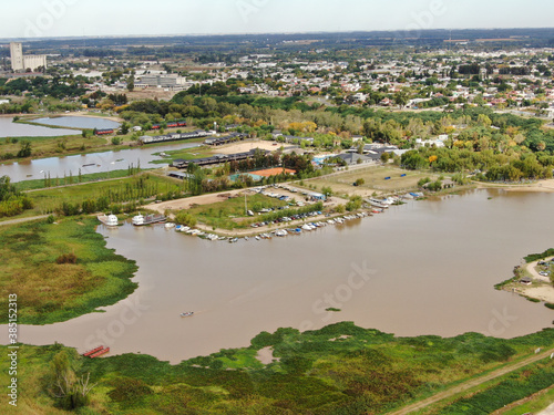 Foto de un dron, de la zona costera de una pequeña ciudad frente a un río. 