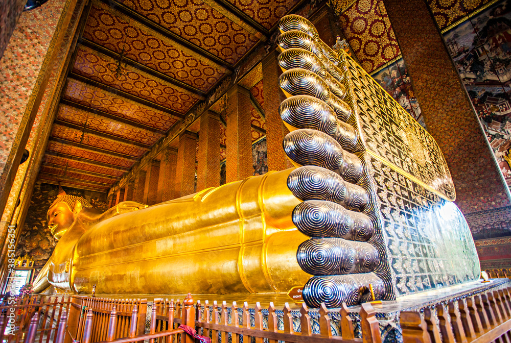 Obraz premium The Big Reclining Buddha statue in Wat Pho Temple, an Asian style Buddha Art, open to worship. Wat Pho is an important temple in Bangkok, Thailand.