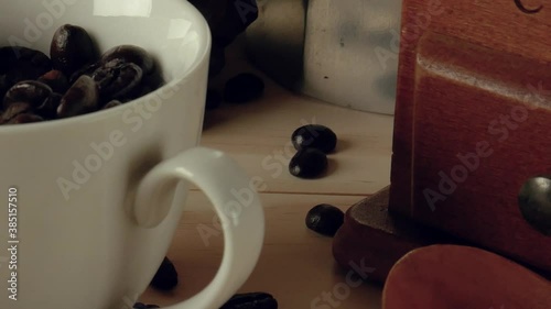 The Coffee beans in white cup on wood table  camera movement.
