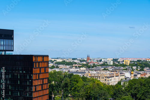 Poland, Lodz, Sky over city with skyscraper in foreground photo