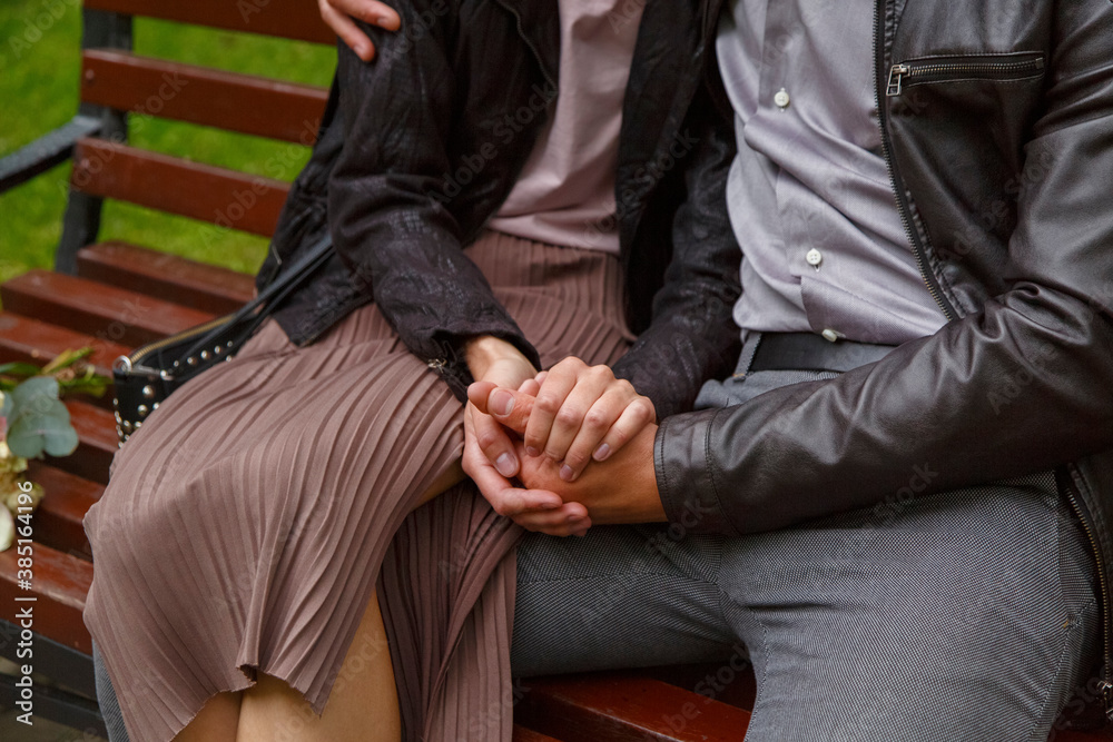 Loving couple hugging on bench in summer park