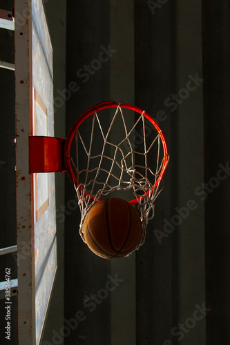 Ball passing through hoop in basket on sports ground