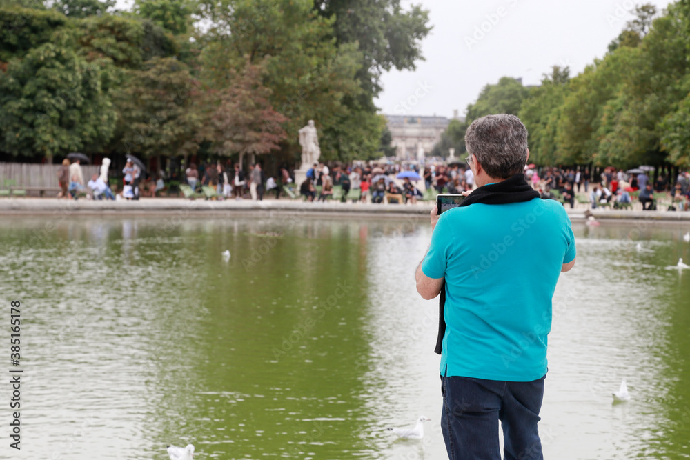 Fototapeta premium Man taking photos in a park in Paris.