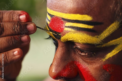 Kathakali dancer doing his make up, Chuvanna Thaadi mask, Kerala, southern India, Asia photo