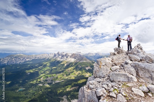 Mountaineers climbing Latemar mountain, fixed rope route, Dolomites, view from Torre Diamantidi mountain, Rosengarten group massif at the back, province of Bolzano-Bozen, Italy, Europe photo