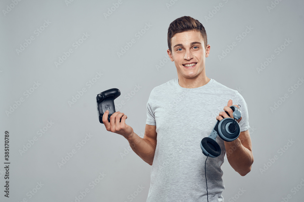 Man with headphones and joystick in hands technology entertainment video games lifestyle addiction light background Man with headphones and joystick in hands technology entertainment video games lifestyle addiction light background