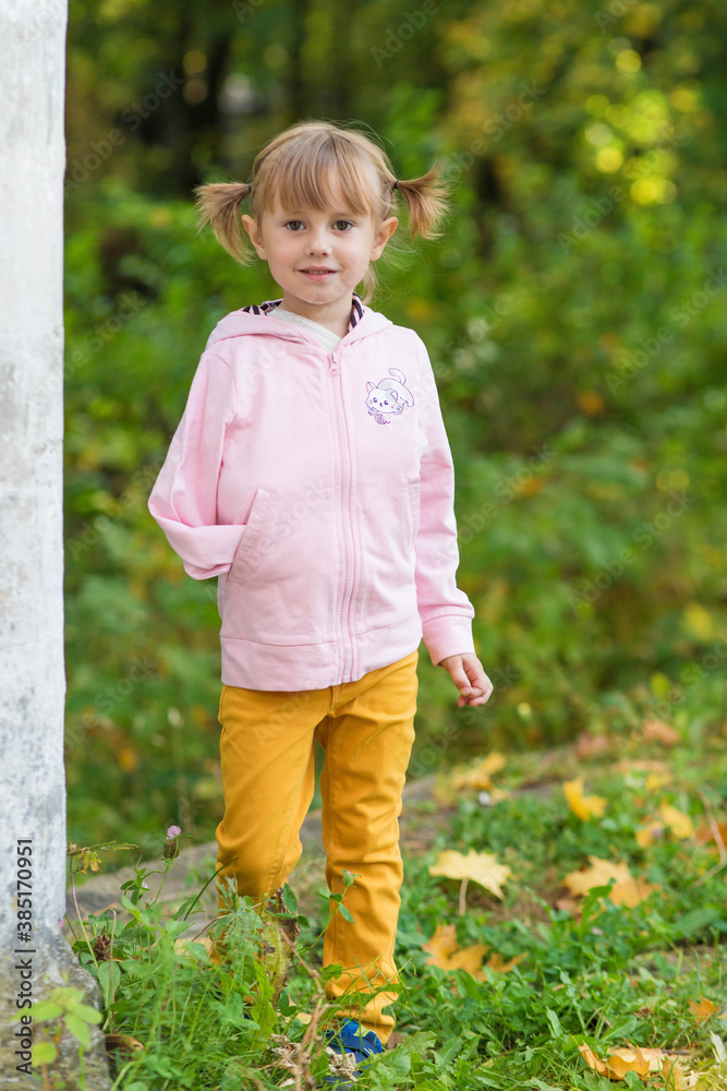 .A girl with a broken arm stands near a column in an old park. .A girl with a broken arm stands near a column in an old park.