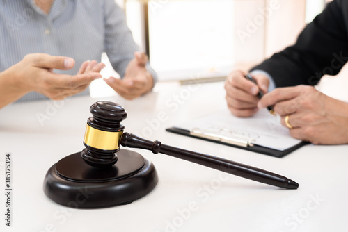 Client with his partner lawyers or attorneys discussing discussing a document or contract agreement working at table in office, Good service cooperation.