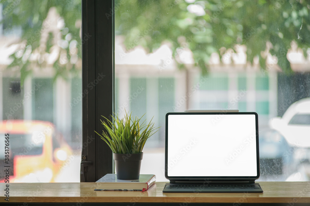 Modern office room with blank screen tablet, camera and office supplies on wood table. Modern office room with blank screen tablet, camera and office supplies on wood table.
