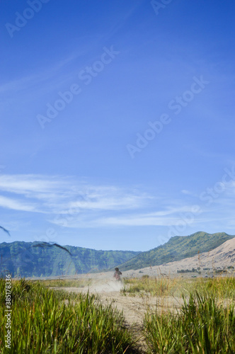 bikers posing in the fields against the mountain background creating a beautiful view