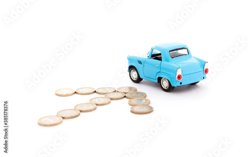 Arrow made up of euro coins pointing at blue car model on white background