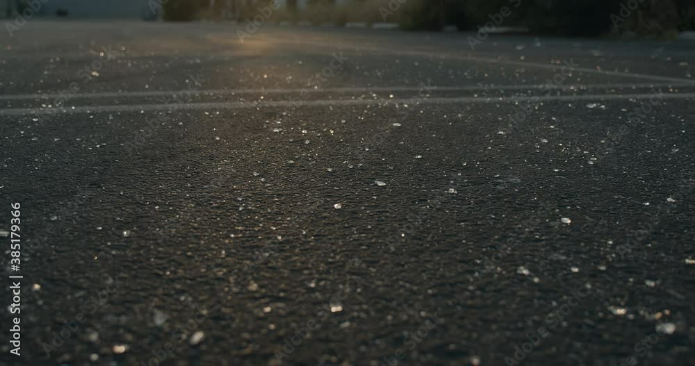Broken glass covered pavement on downtown street Broken glass covered pavement on downtown street